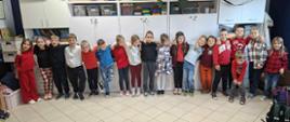 Grupa dzieci stojących obok siebie obejmujących się na ramionach