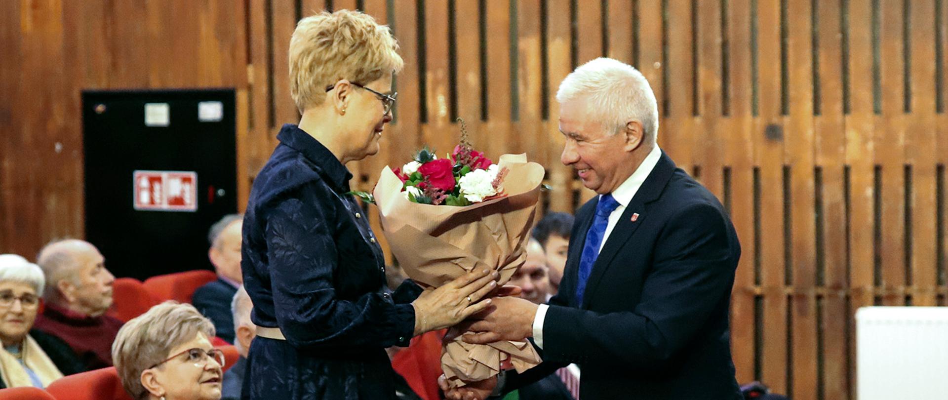 Starosta Andrzej Rolla wręcza symboliczne kwiaty dyrektor Grażynie Jach