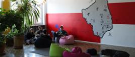 strefa relaksu - na korytarzu stoją pufy, na ścianie mural