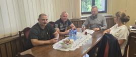 Cztery osoby siedzą przy stole w biurze