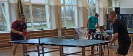 Dwóch uczestników przy stole tenisowym rozgrywa mecz