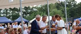 Pani Wójt częstująca gości chlebem dożynkowym