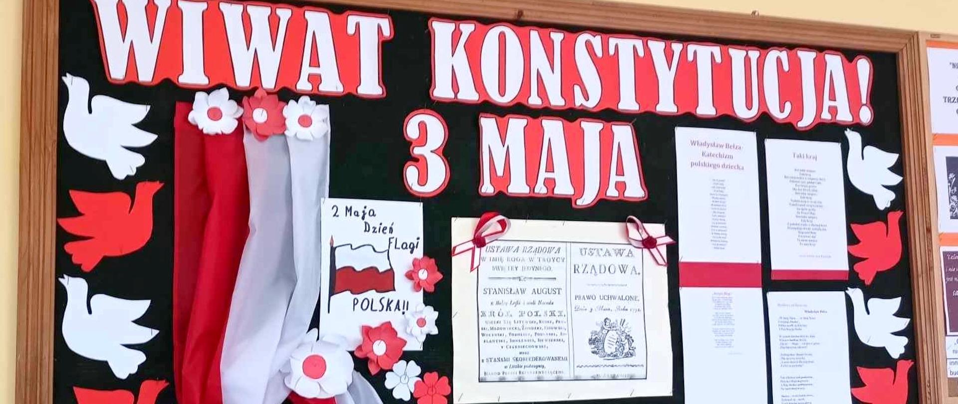 Gazetka ścienna przedstawiająca biało-czerwony napis WIWAT KONSTYTUCJA 3 MAJA oraz symbole świąteczne: flagę, gołąbki, kwiaty, patriotyczne wiersze, stronę tytułową konstytucji 3 maja