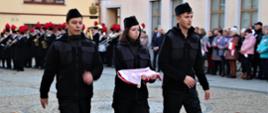 Dzieci idą z flagą do masztu