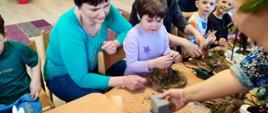 Rodzicie i dzieci wspólnie robią stroiki wielkanocne