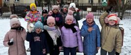 Dzieci pozują do zdjęcia, na twarzach mają namalowane kocie wąsiki