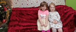 Dzieci pozują siedząc na sofie, nad nimi, na ścianie napis "Magiczny czas".