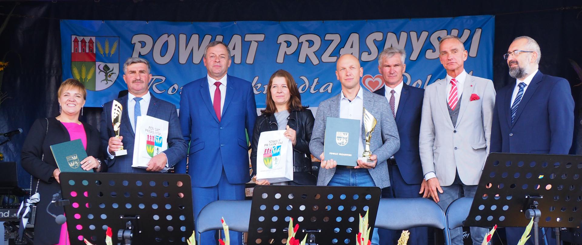 Wręczenie nagród dla najlepszych rolników w powiecie przasnyskim. Na scenie dożynkowej stoją samorządowcy Starosta Przasnyski, Wójt Gminy Czernice Borowe Wojciech Brzeziński, Przewodniczący Rady Gminy Czernice Borowe i Senatorem Jana Marii Jackowskiego wraz z nagrodzonymi rolnikami z terenu gminy Czernice Borowe.