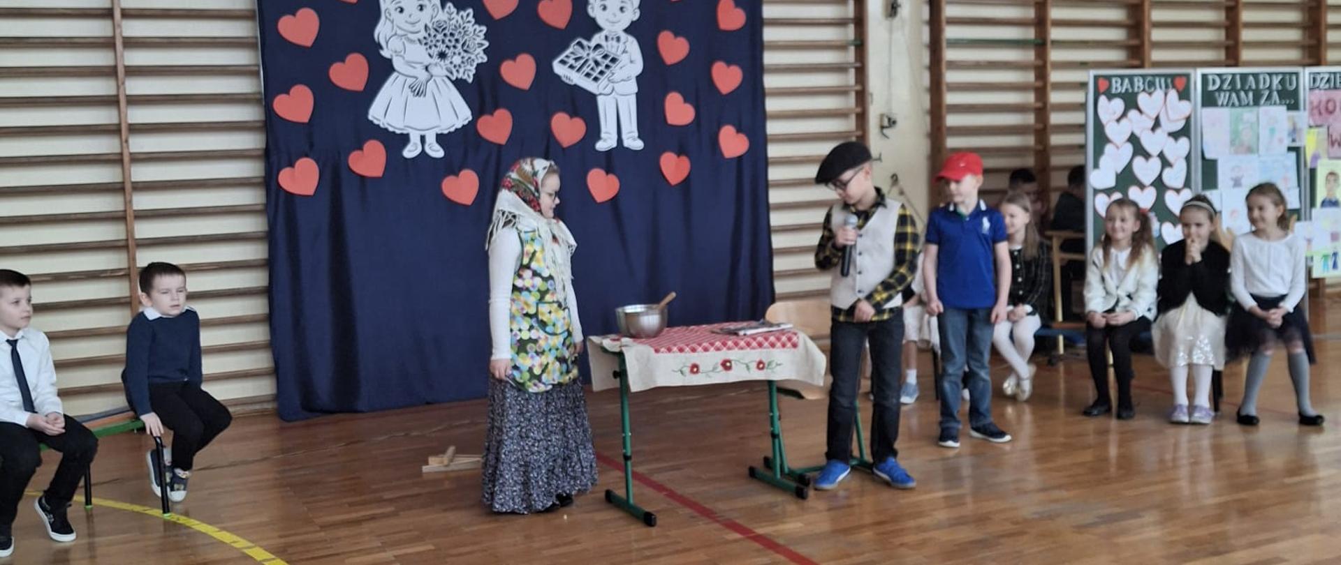 Uczniowie klasy 1 a w strojach dziadków podczas przedstawienia.