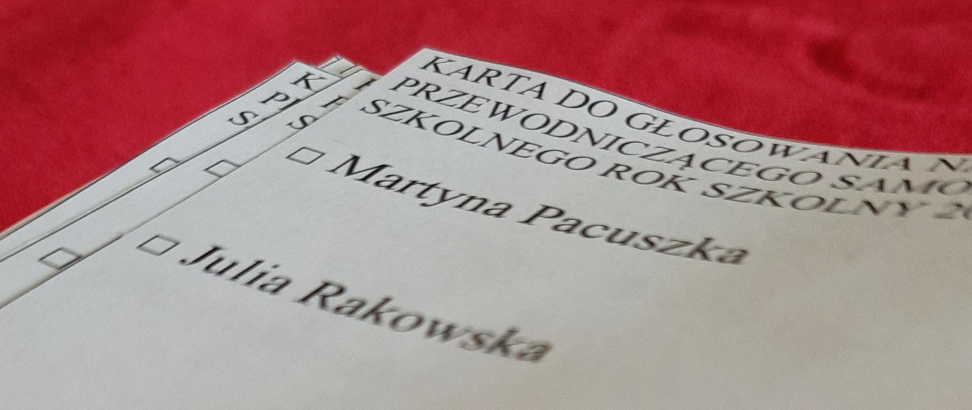 Stos kartek leżących na czerwonym stole