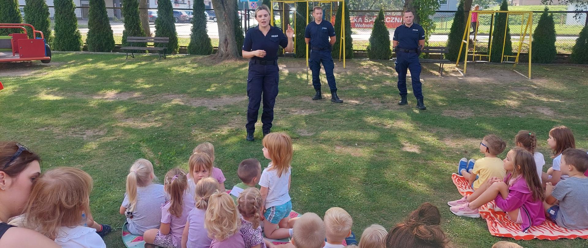 3 policjantów przed grupą dzieci