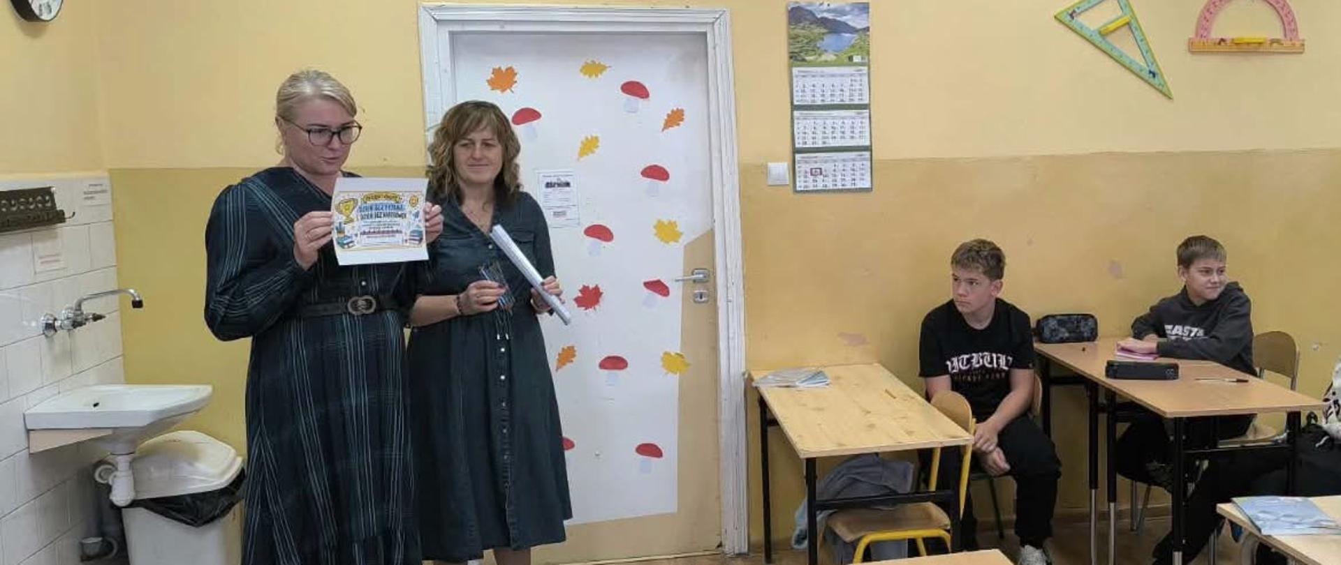 Pani dyrektor wraz z panią pedagog ogłaszają w klasie konkurs związany z przeciwdziałaniem przemocy