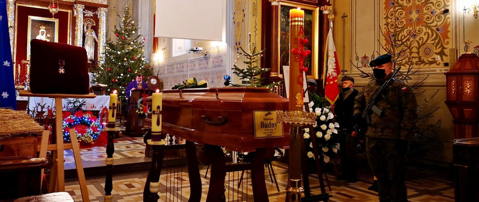 Zdjęcie przedstawia trumnę, w której spoczywa porucznik Stanisław Budny oraz żołnierza 2. Ośrodka Radioelektronicznego w Przasnyszu pełniącego wartę honorową, kościół parafialny w Czernicach Borowych.