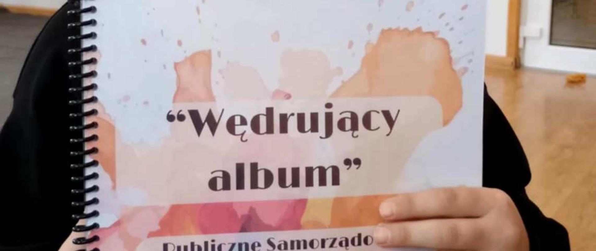 Dziewczynka trzymająca „Wędrujący album”.