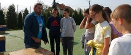 Uczniowie na boisku szkolnym oglądają eksponaty Podkarpackiego Centrum Nauki „Łukasiewicz”