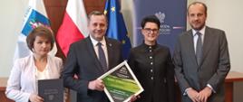 od lewej Pani Skarbnik Beata Kalemba, Wójt Gminy Raba Wyżna Tomasz Rajca oraz przedstawiciele Wojewody Małopolskiego. W tle widać roll up wojewoda Małopolski oraz 3 flagi , flaga Nowego Targu z herbem, Flaga Polski oraz Flaga Unii Europejskiej. 