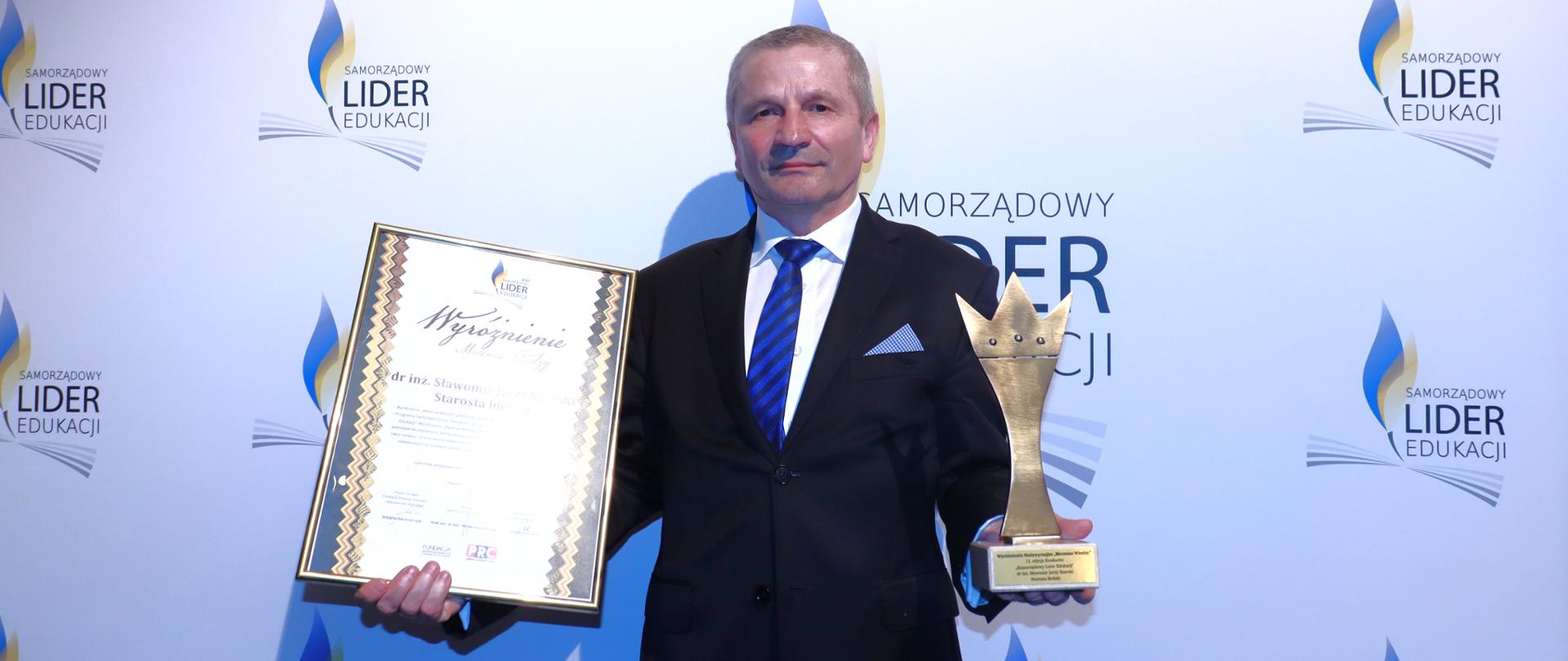 Naczelnik wydziału oświaty Anatol Grzegorz Tymiński w imieniu starosty bielskiego Sławomira Jerzego Snarskiego odbiera wyróżnienie "Mecenas Wiedzy"