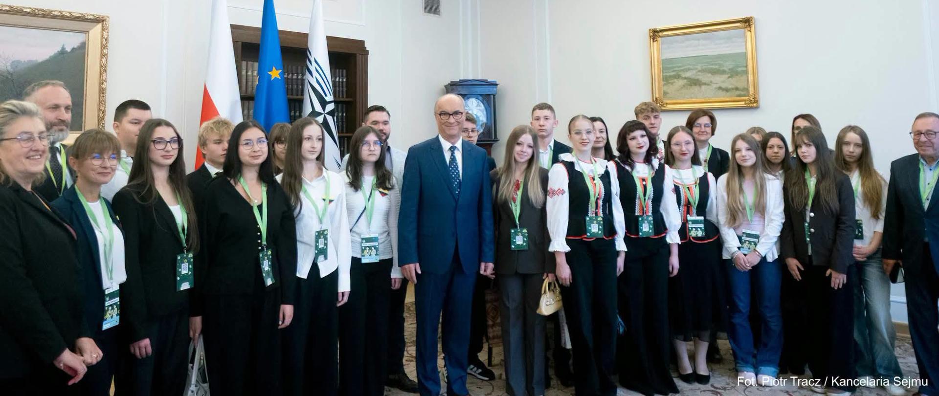 Marszałek Sejmu Włodzimierz Czarzasty pozuje do zdjęcia z uczniami 