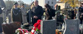Przedstawiciele władz samorządowych, służb mundurowych i zaproszeni goście podczas uroczystości przy grobie wojennym harcerza Zdzisława Ołtuszewskiego na cmentarzu parafialnym w Kobiórze. Na grobie złożono kwiaty i wieńce w biało-czerwonych barwach.