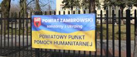 na 1 planie zdjęcia znajduje się banner powiatowego punktu pomocy humanitarnej w Zambrowie, natomiast na drugim planie budynek ZS1 "stołówka"