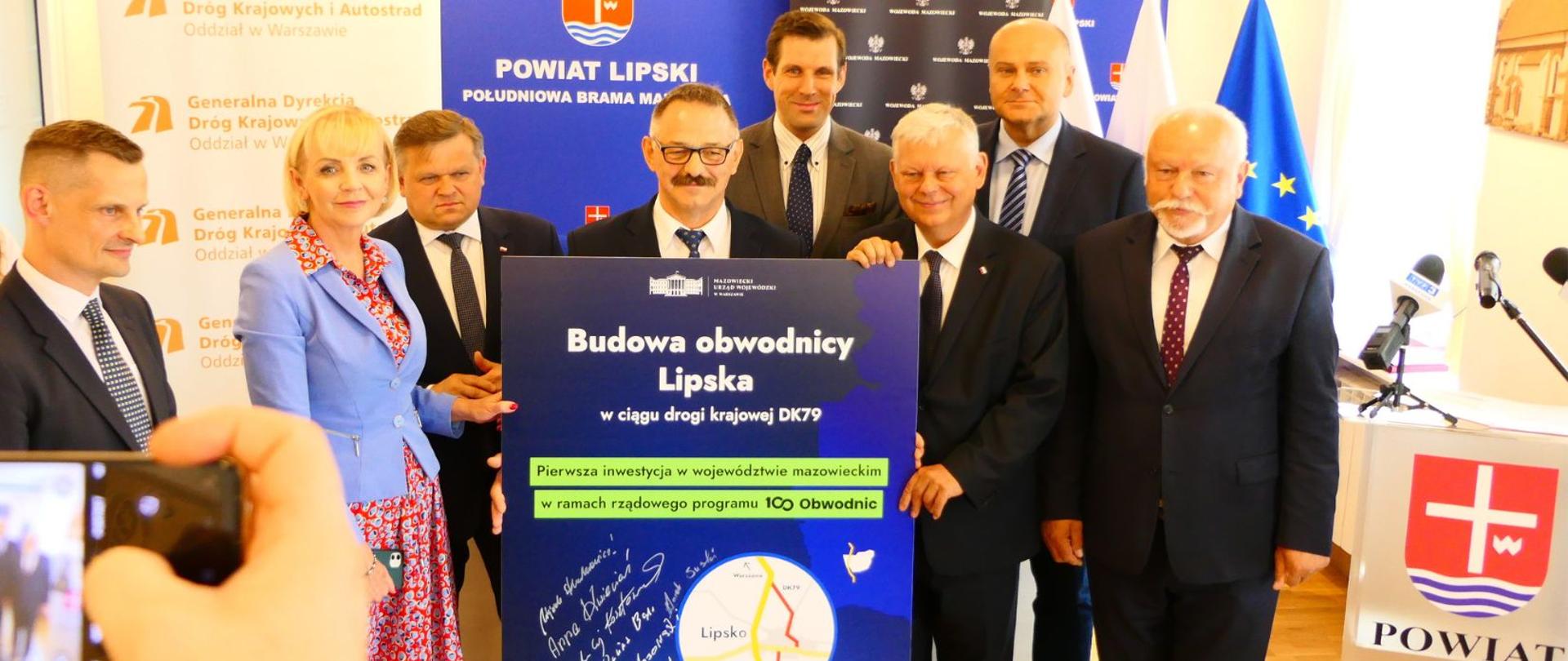 Uczestnicy wydarzenia trzymają pamiątkową tablicę z podpisami dotyczącą budowy obwodnicy Lipska.