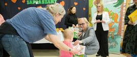 Dyrektor Przedszkola wręcza dziecku upominek