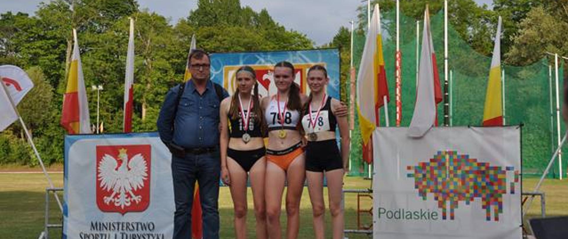 Zwyciężczynie zawodów pozują z trenerem Romanem Sacharczukiem 