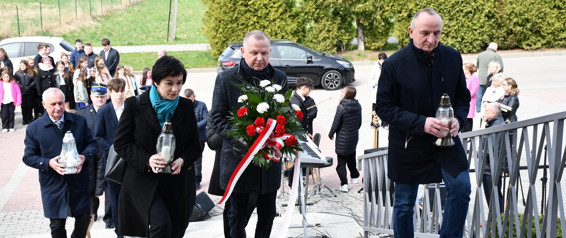 Starosta Dąbrowski, Wicestarosta oraz Przewodnicząca Rady Powiatu składają wiązankę i kwiaty przed tablicą