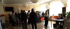 Szkolny korytarz - przy stoiskach edukacyjnych, przygotowanych przez uczniów szkoły stoją ósmoklasiści