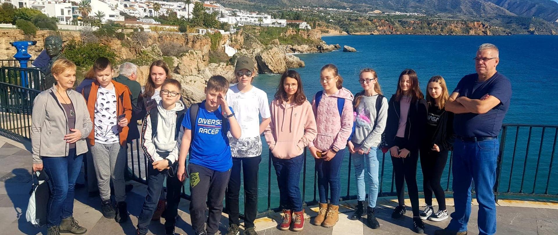 Uczniowie i nauczyciele z białowieskiej szkoły podczas pobytu w Hiszpanii - grupa pozuje na tle morza