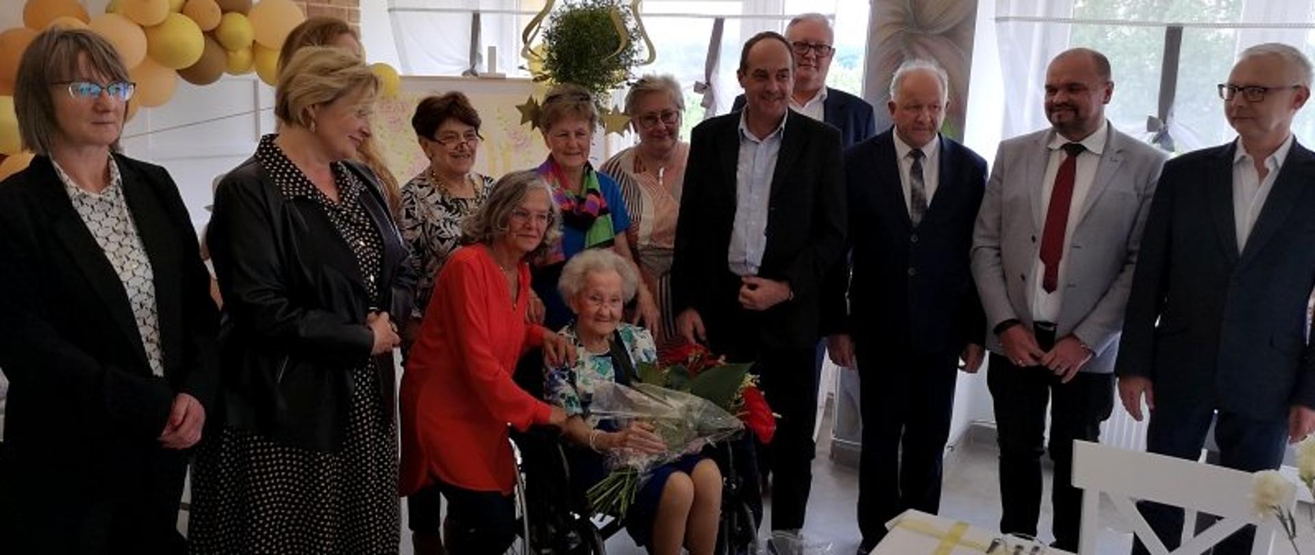100 lat pani Ludwiki, zdjęcie grupowe w centralnym miejscu pani Ludwika - 100 latka w otoczeniu córki, wnuka i gości. 