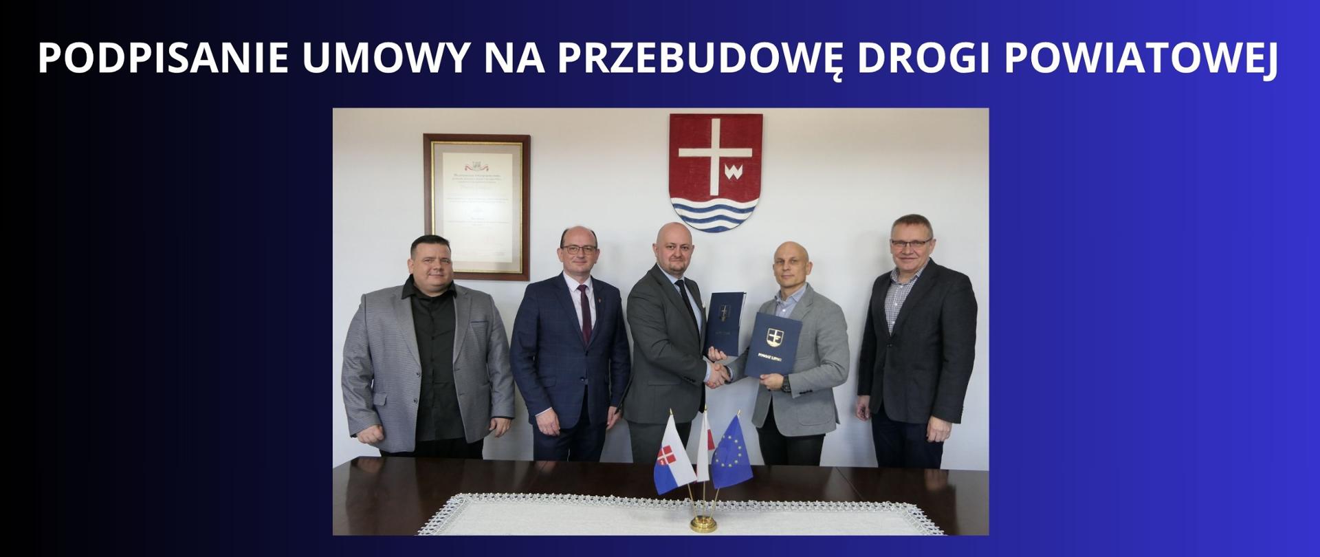BIAŁY NAPIS NA GRANATOWO CZARNYM TLE " PoDPISANIE UMOWY NA PRZEBUDOWĘ DROGI POWIATOWEJ" ZDJĘCIE STAROSTY LIPSKIEGO ORAZ WICESTAROSTY Z WYKONAWCA INWESTYCJI FIRMĄ BUDROMOST , NA ZDJĘCIU DYREKTOR PZDP W LIPSKU , UŚCIŚNIĘCIE DŁOŃI PO PODPISANIU UMOWY 