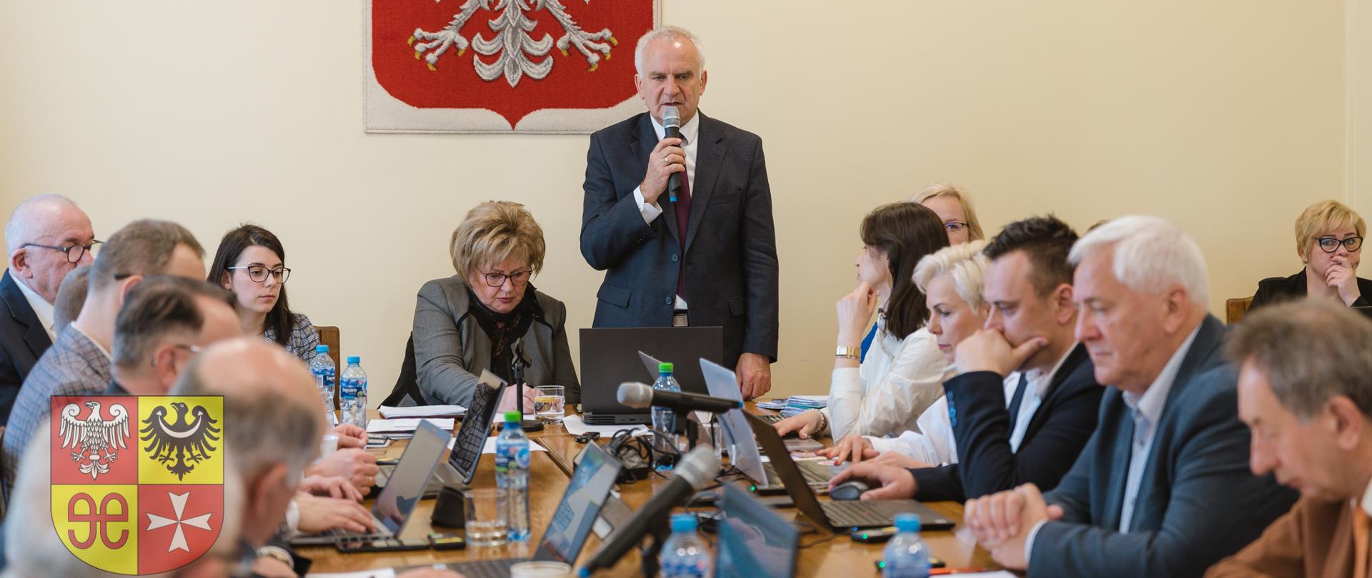 grupa ludzi wewnątrz, przy stole do obrad