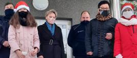Wójt Apolonia Stasiuk z uczennicami Julką Olszewską i Amelką Borychowską, kierownik GOPS Teresą Stasiuk oraz Panami policjantami przed budynkiem gminy