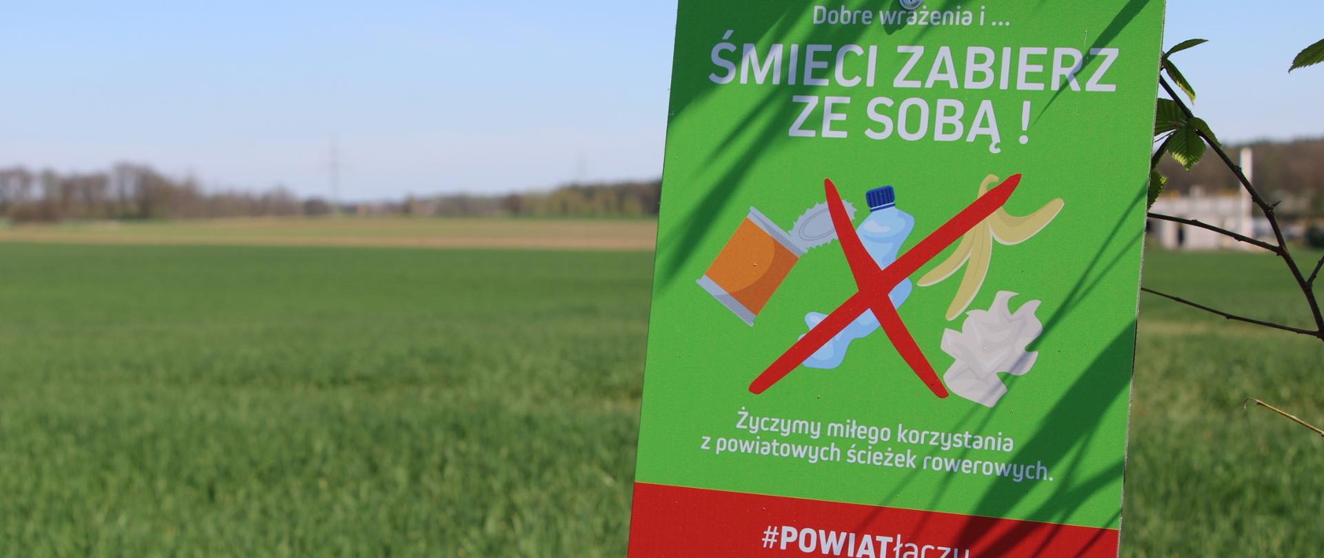 Tabliczka na tle pola.