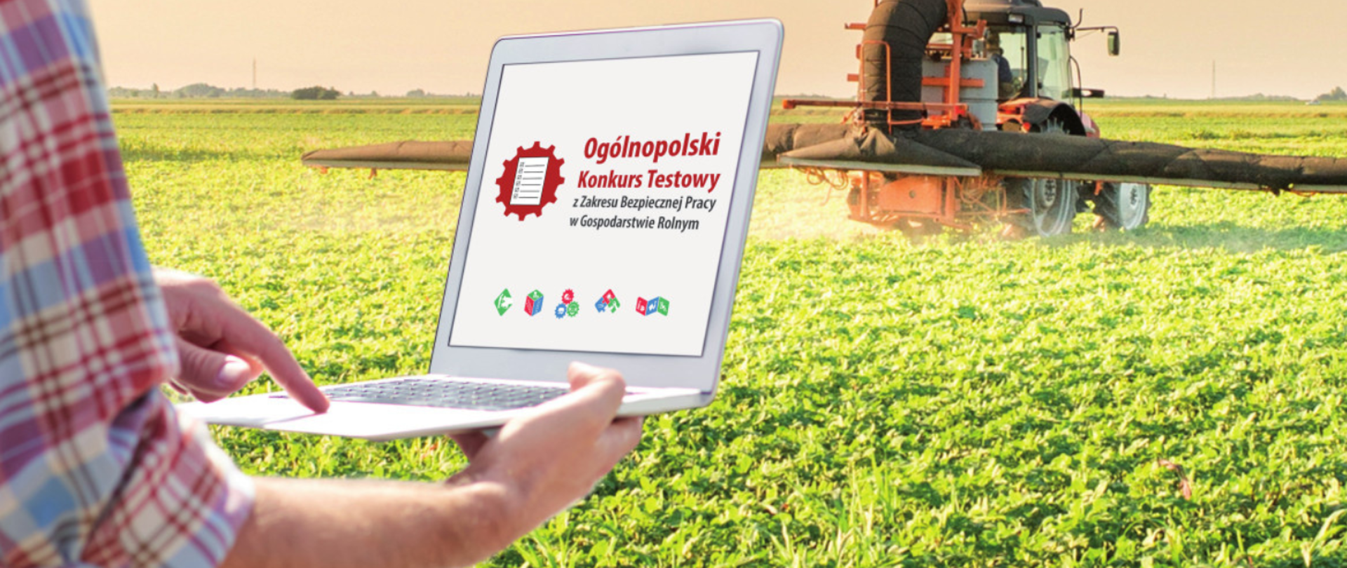 Zdjęcie człowieka z laptopem na tle pola uprawnego, w oddali traktor opryskujący uprawy