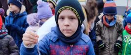 Chłopiec pozuje do zdjęcia z kulką dla ptaków