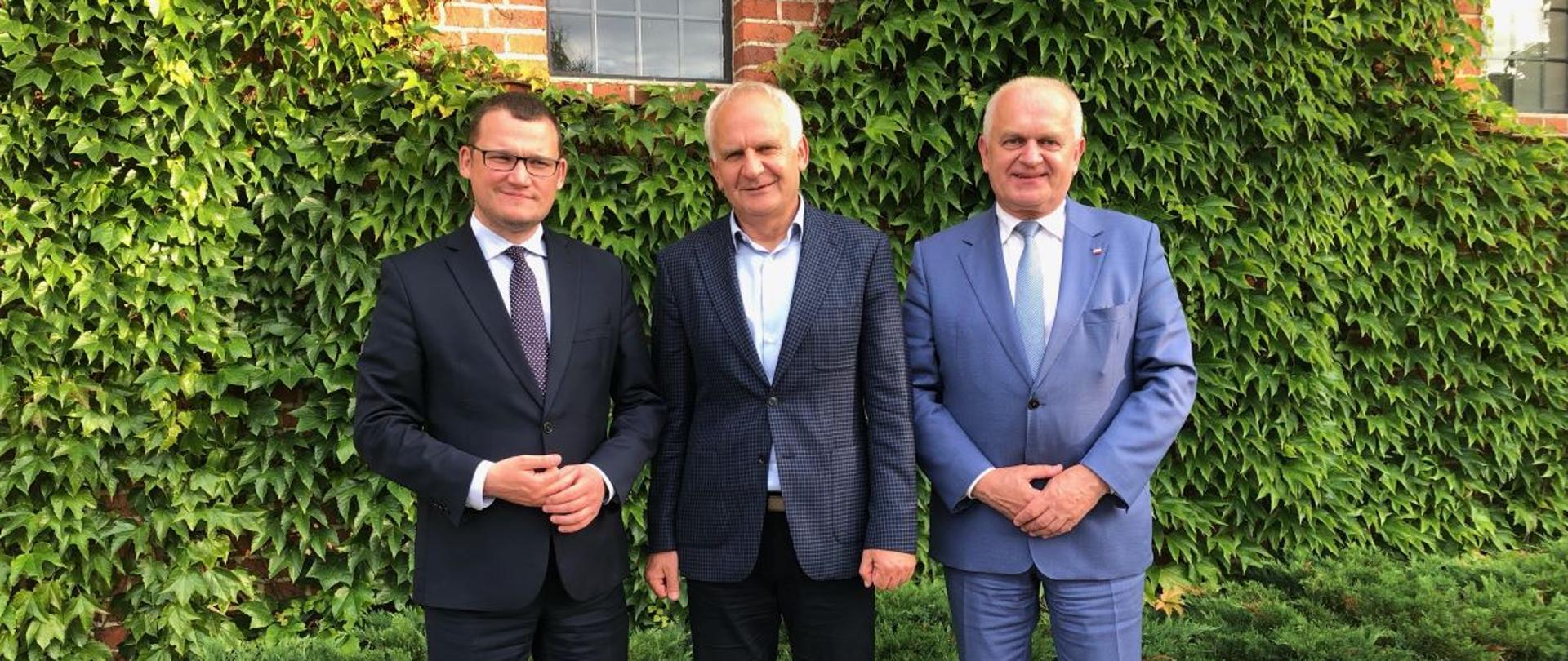 trzej mężczyźni w garniturach na zewnątrz