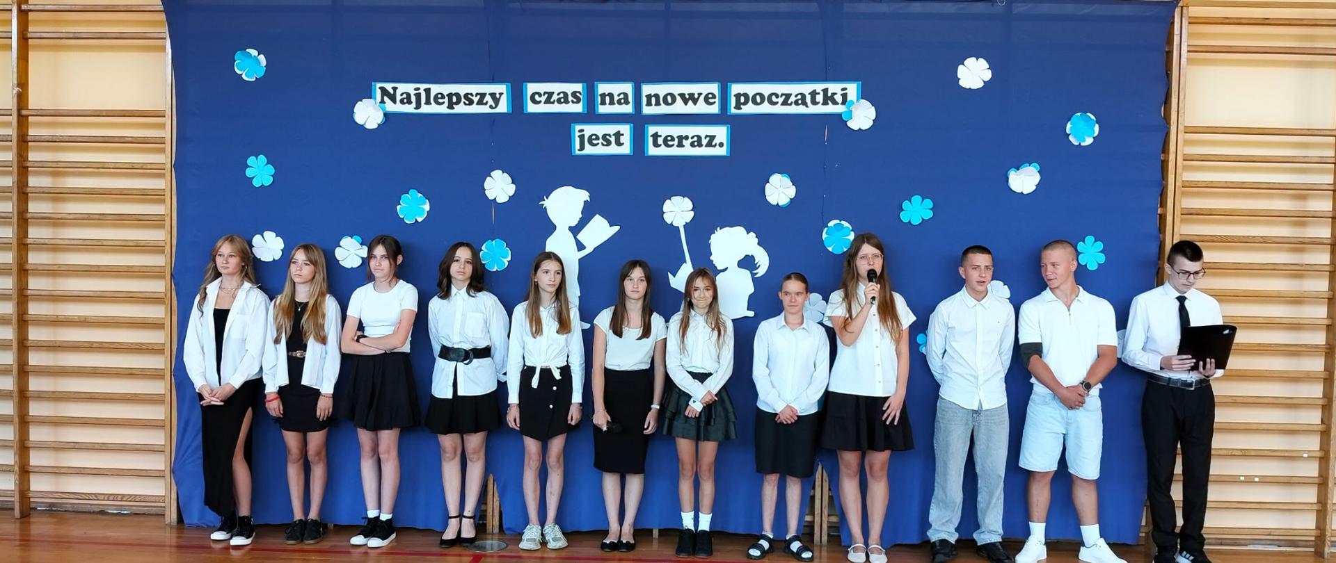 Uczniowie klasy 8b w strojach występują podczas akademii na rozpoczęcie roku szkolnego