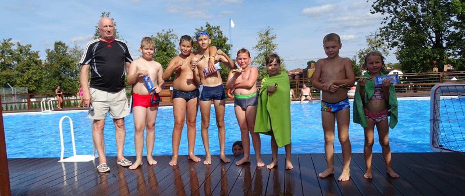 Organizator pozuje do zdjęcia z dziećmi, które wzięły udział w zawodach