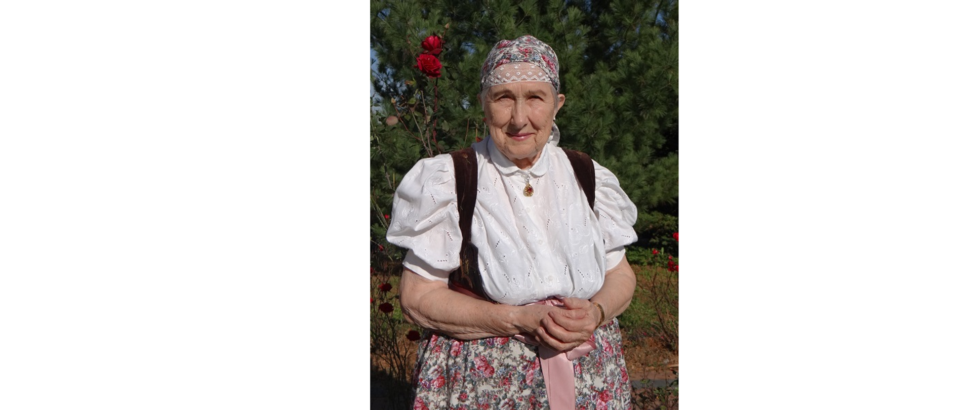 Anna Kałuża, Laureatka "Srebrnej Cieszynianki". Pozuje do fotografii w swoim ogrodzie, ubrana w tradycyjny cieszyński strój regionalny.
