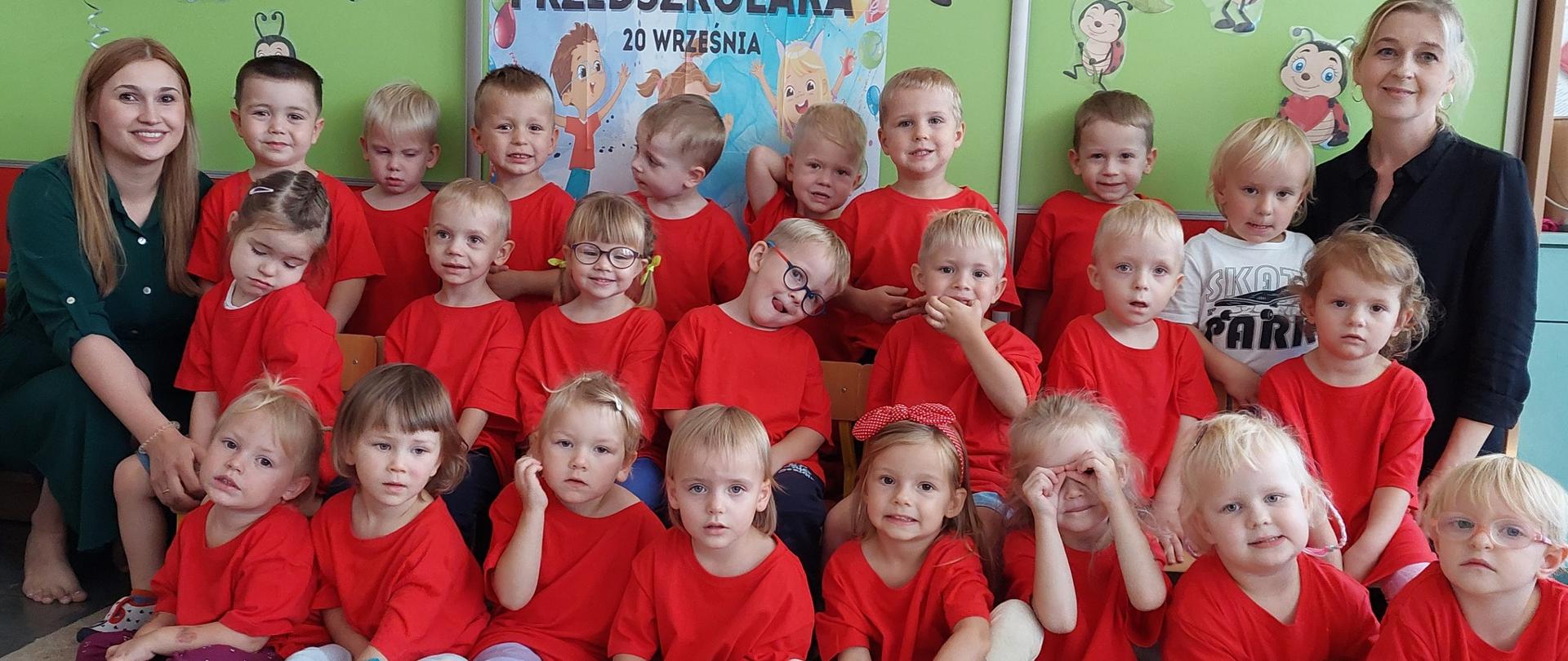 2 dorosłe kobiety i grupa dzieci w czerwonych koszulkach