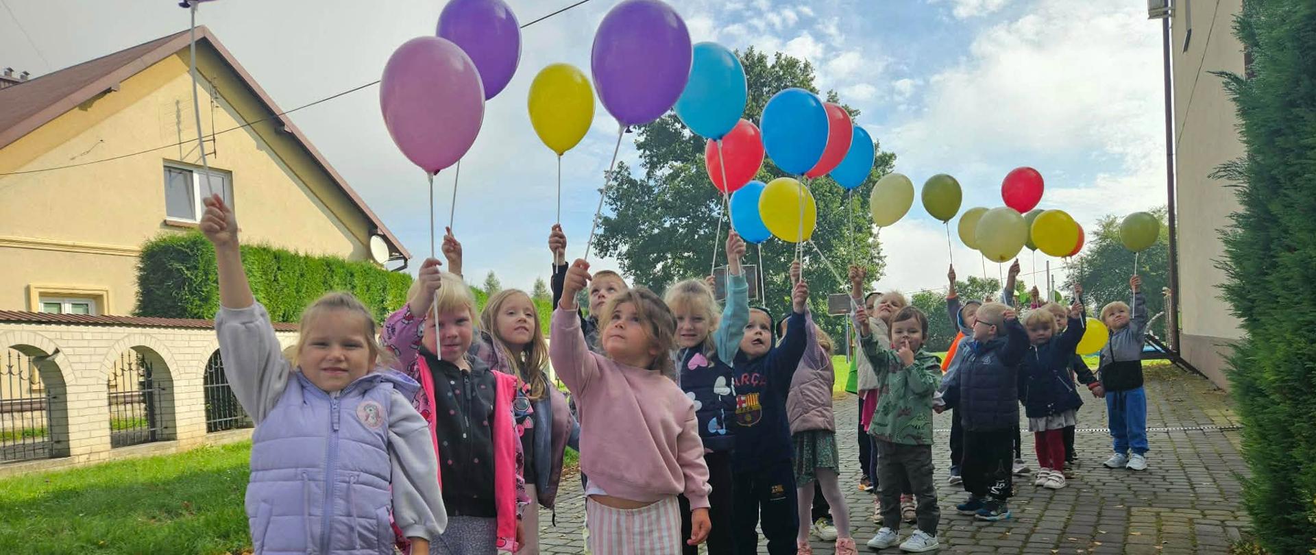Grupa dzieci z balonami podczas przemarszu z Okazji Dnia Przedszkolaka